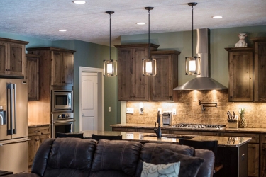 wider view of open kitchen with island and darker finish