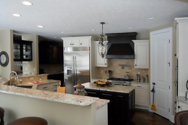 custom white kitchen with darker island and range hood